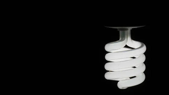 Energiesparlampe vor schwarzem Hintergrund